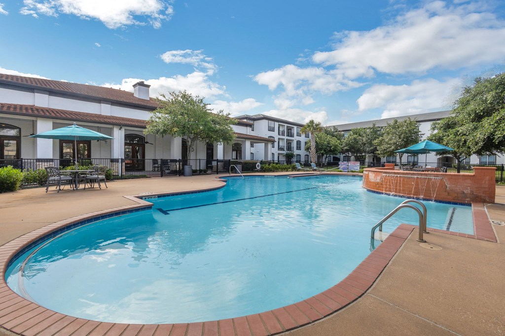 a large swimming pool with a hotel in the background