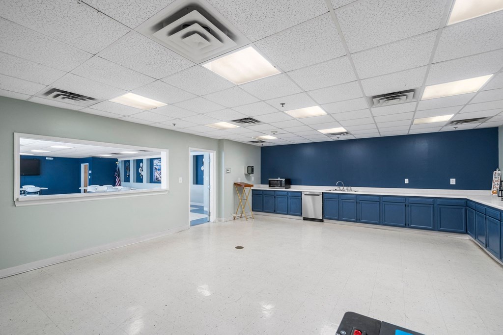 an empty room with a sink and a counter in the middle of it