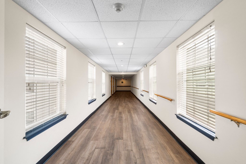 A long hallway with wooden floors and white walls.