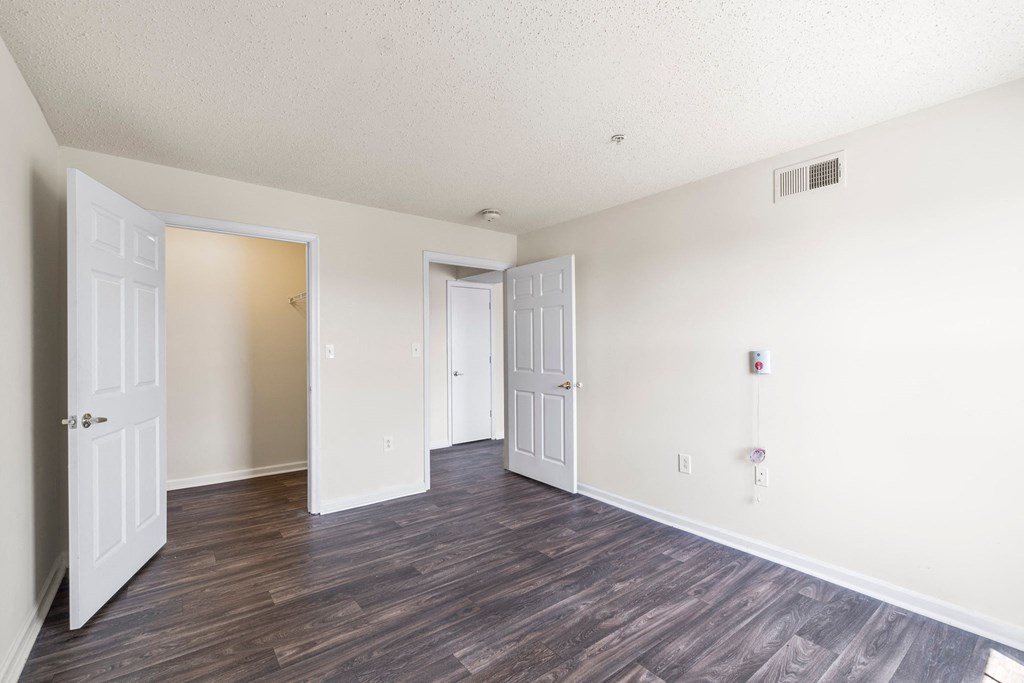 an empty living room with white walls and wood flooring