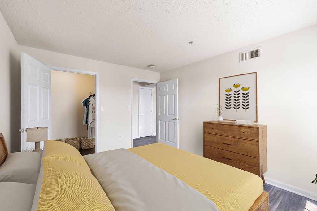 A bedroom with two beds and a dresser with a picture frame on top.