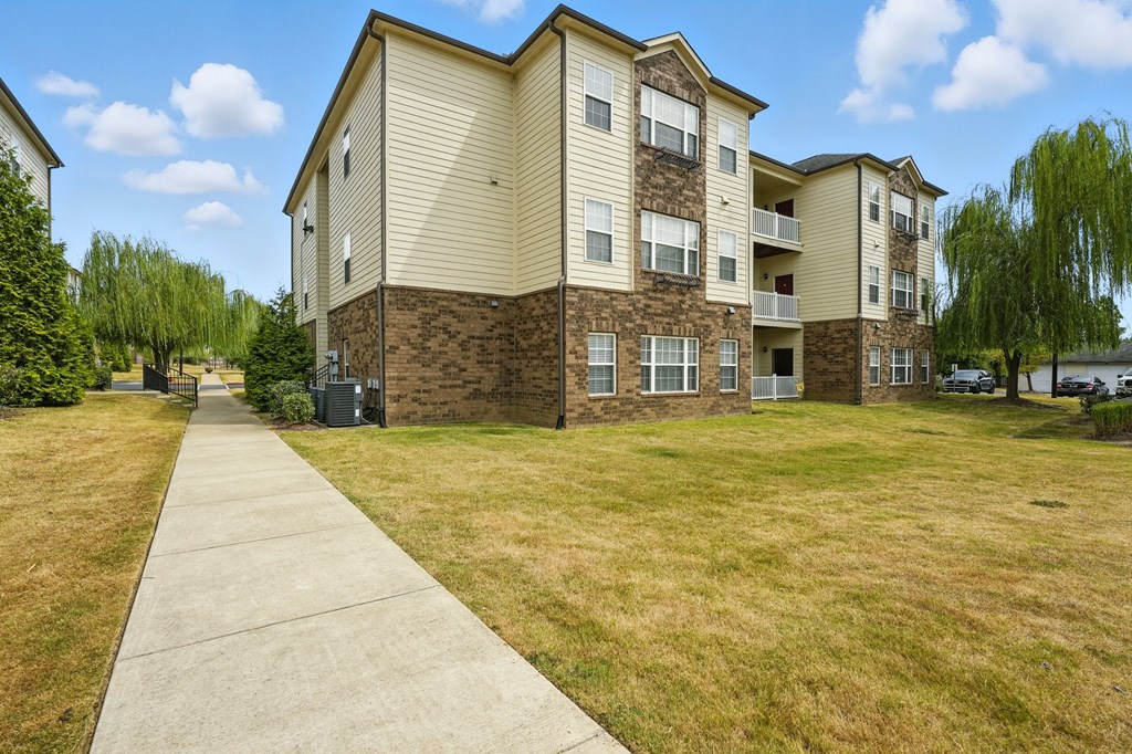 Apartment building with a sidewalk in front.
