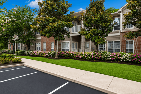 A street view of a residential area with apartment buildings and a sidewalk.