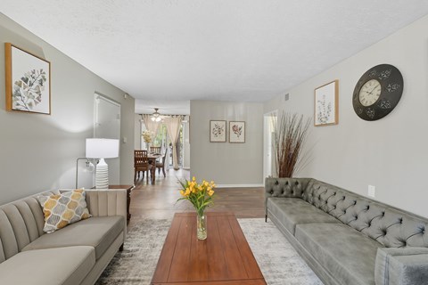 A living room with a grey couch and a wooden table.
