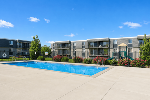 A swimming pool in front of apartment buildings.