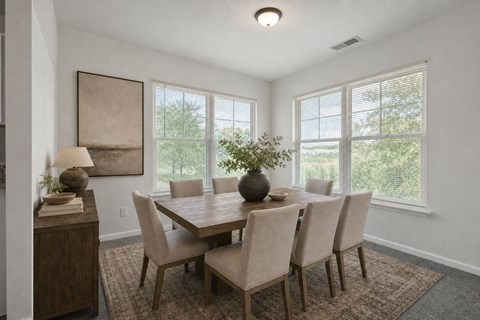 A dining room with a table and chairs.
