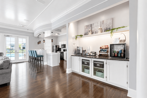 A kitchen with a white cabinet and a grey sofa.
