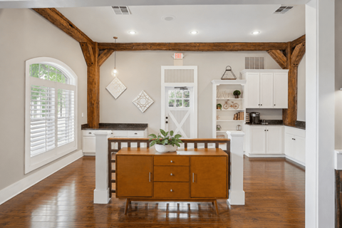 A kitchen with white cabinets and a wooden floor.