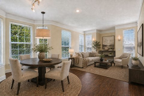 A well-lit living room with a round table and chairs.