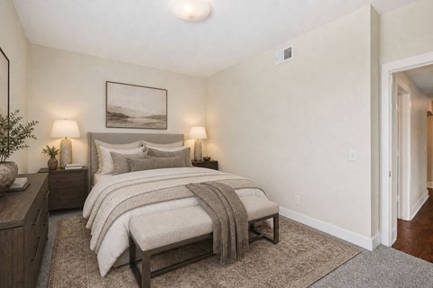 A bedroom with a large bed and a painting on the wall.
