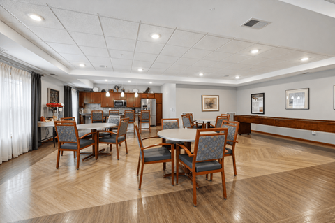 A dining room with a table surrounded by chairs.