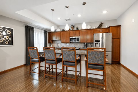 A kitchen with a table and chairs.