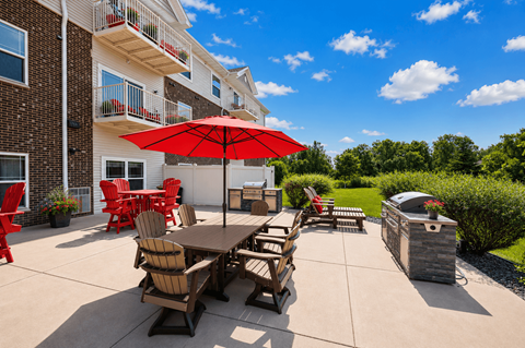 A patio with a table and chairs and an umbrella.