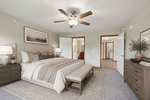 A bedroom with a large bed and a ceiling fan.
