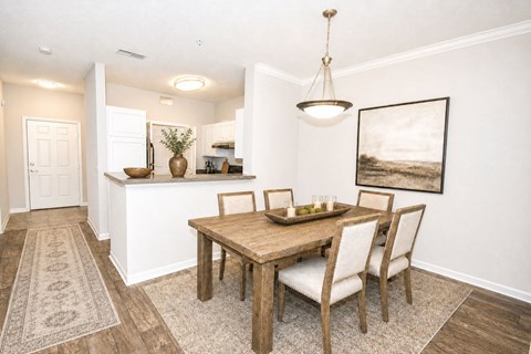 A dining room with a wooden table and chairs.