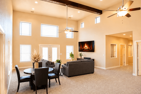 A living room with a fireplace and a dining table.