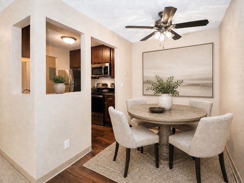 A dining room with a round table and chairs.