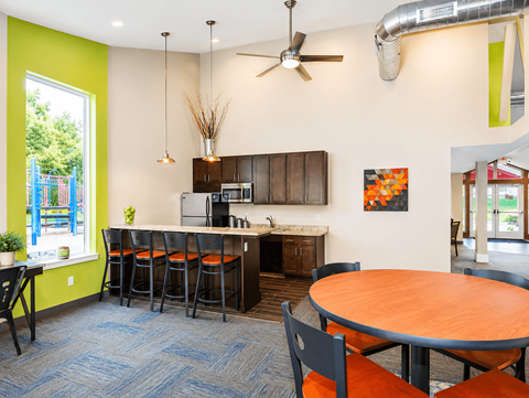 A kitchen with a table and chairs.