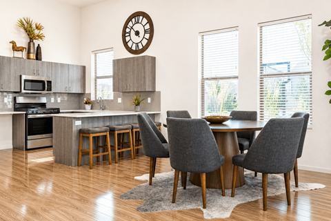 A kitchen with a table and chairs in front of a window.