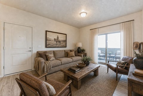 A living room with a couch, a chair, a coffee table, and a painting on the wall.