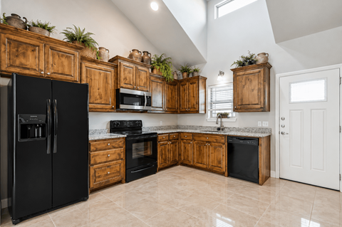 A kitchen with black appliances and wooden cabinets.
