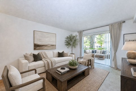 A living room with a white couch, a coffee table, and a painting on the wall.