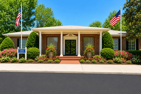 A house with a front yard and two American flags on poles.