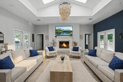 A living room with a fireplace and a television mounted above it.