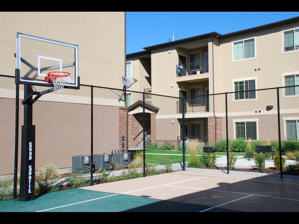 an outdoor basketball court in front of an apartment building