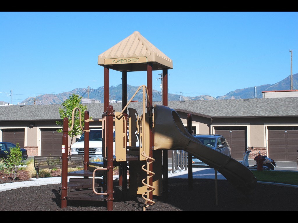 a playground with a slide in front of a house