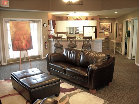 a living room with a leather couch and a painting