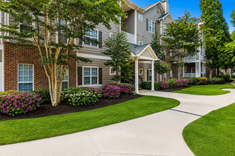 A residential area with apartment buildings and a well-maintained lawn.