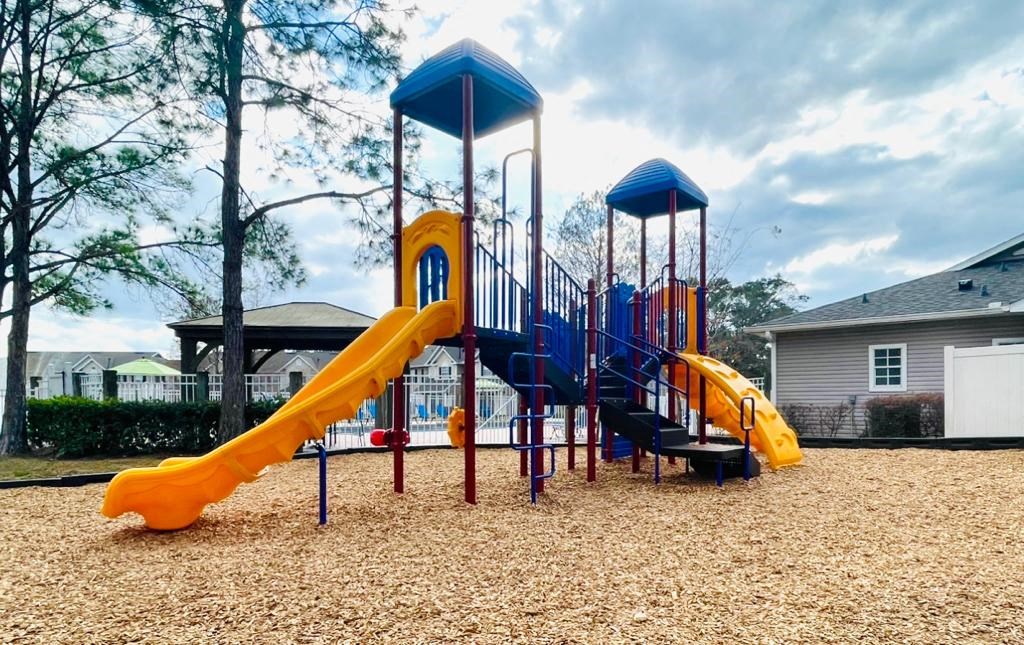 a playground with a blue and yellow swing set