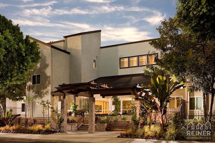 a house with a patio and trees in front of it