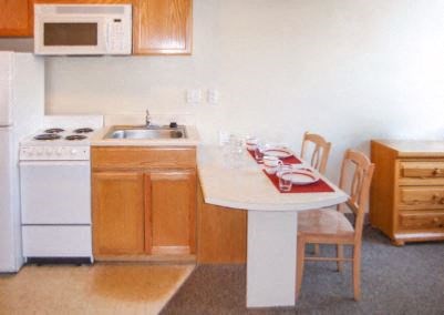 a kitchen with a table and a stove and a microwave