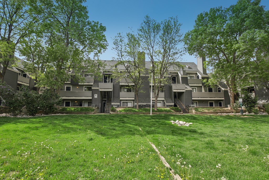 A large, well-maintained lawn in front of a row of houses.