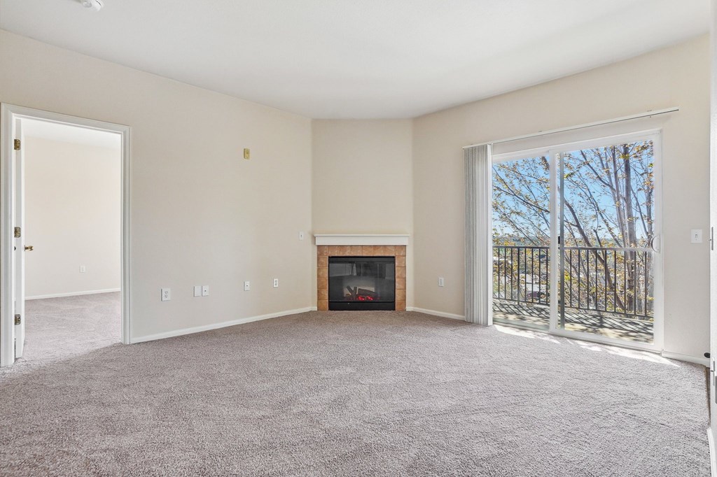 A living room with a fireplace and a sliding glass door. at Stetson Meadows Apartments, Colorado Springs, CO