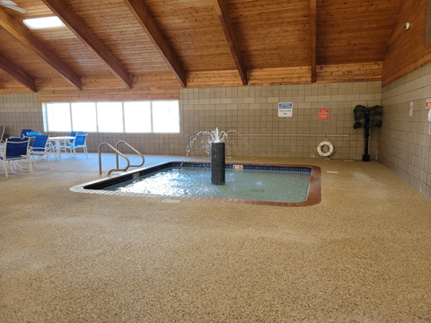 a large indoor jacuzzi in a building with wood ceilings and flooring