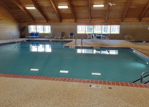 a large indoor swimming pool with chairs on the side
