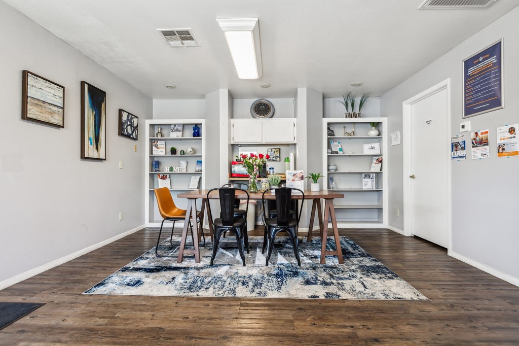 a dining room with a wooden table and chairs and a book shelf
