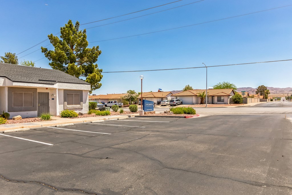 an empty parking lot in front of a building with a sign in the street