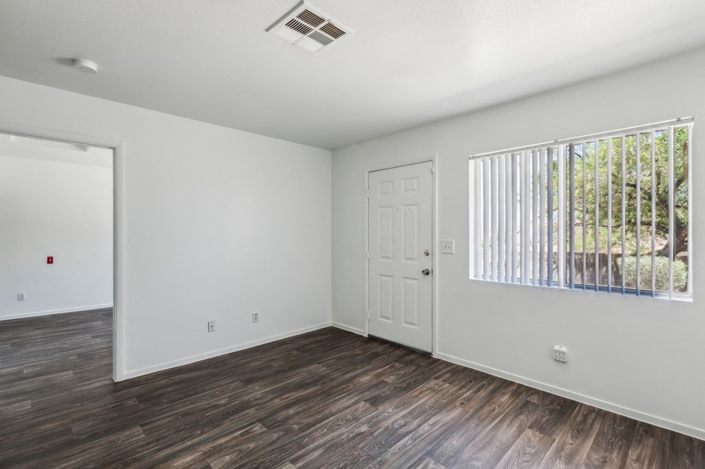 the living room of an empty house with a window and a door