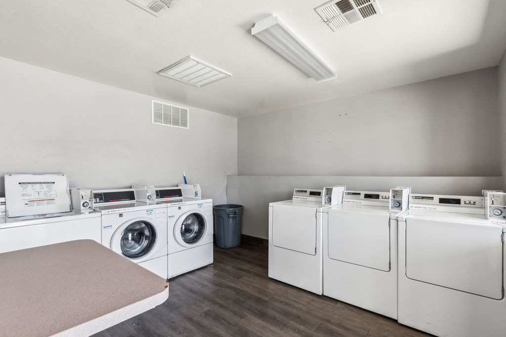 a laundry room with washers and dryers and a row of washing machines