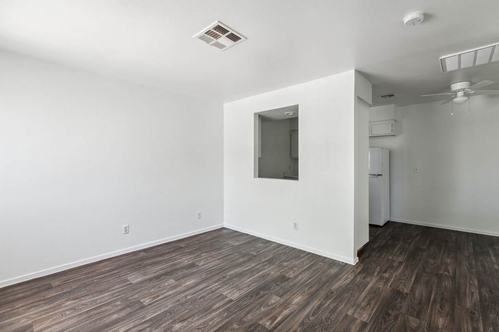 an empty living room with white walls and wood flooring