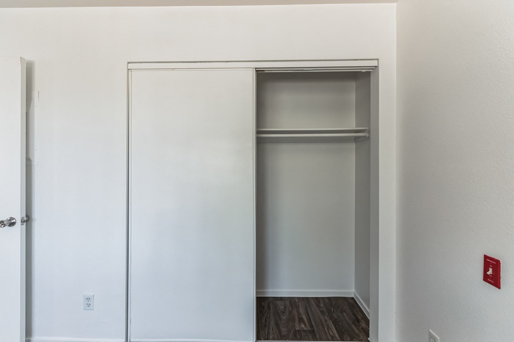 an empty closet in an empty room with a door open