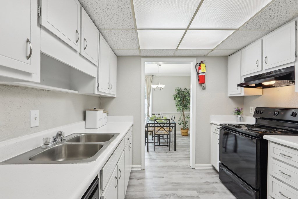 A kitchen with white cabinets and a black stove top oven.