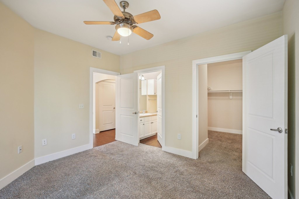 A room with a ceiling fan and carpeted floor. at Province of Briarcliff Apartments, Missouri, 64118