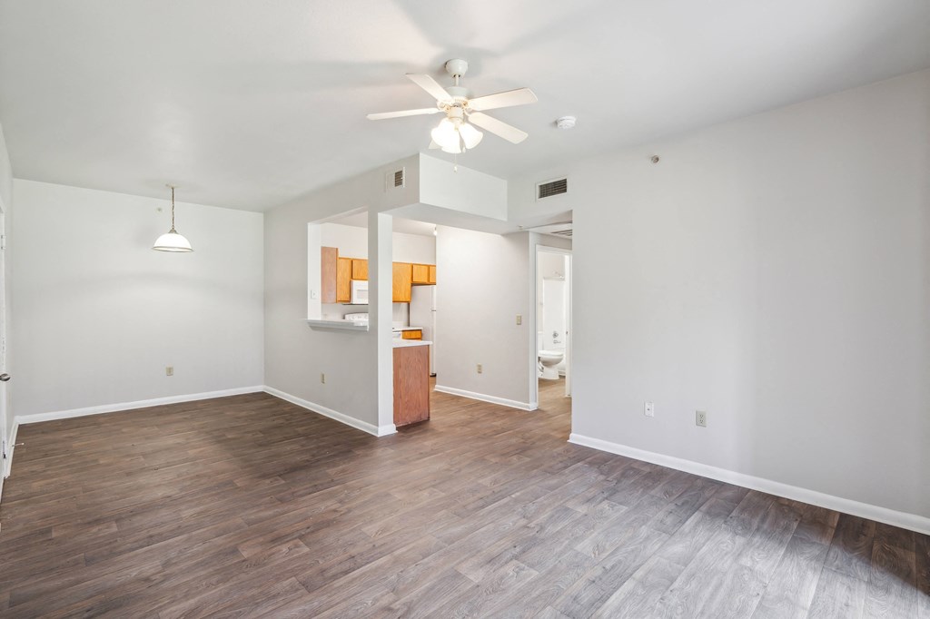 a living room with white walls and a ceiling fan
