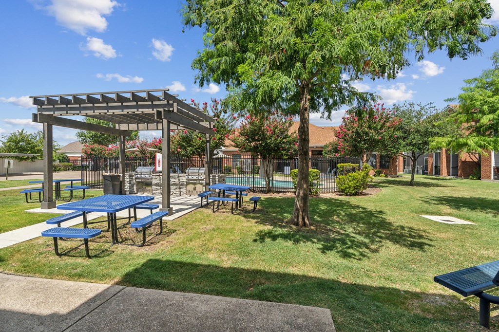 a picnic area with picnic tables and a shade