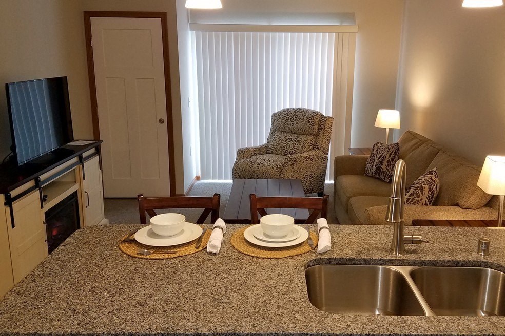 a kitchen and living room with a sink and a table